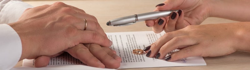 Two people signing divorce documents